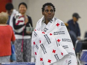 An evacuee rests at the George R. Brown Convention Center in Houston, Monday, Aug. 28, 2017.  Houston was still largely paralyzed Monday, and there was no relief in sight from the storm that spun into Texas as a Category 4 hurricane, then parked itself over the Gulf Coast. (Scott Clause/The Daily Advertiser via AP)