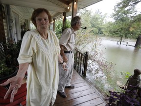 Brenda Bradley speaks about the flooding in her neighborhood in Moss Bluff, a Lake Charles, La., suburb in Calcasieu Parish, Monday, Aug. 28, 2017. Bradley, 72, and her husband, Jimmie, right, had stacked sandbags at their doors, but the rising water was lapping at the steps to their back porch and had overtaken their front yard. Virtually every neighbor on Crawford Drive has at least a foot of water in their yards. (AP Photo/Rogelio V. Solis)