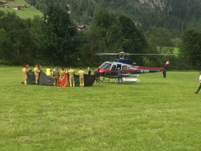 Rescue workers stand next to a police helicopter in Krimml in the Austrian province of Salzburg, Sunday, Aug. 27, 2017. The Austrian Red Cross said five mountain climbers died Sunday in the Austrian Alps in Wildgerlostal on Mount Gabler, east of Innsbruck, and a sixth climber was severely injured, the Austrian news agency APA reported. (AP Photo/Franz Brinek)