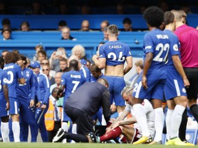 Chelsea's Gary Cahill, centre, leaves the pitch after getting a red card during the English Premier League soccer match between Chelsea and Burnley at Stamford Bridge stadium in London, Saturday, Aug. 12, 2017. (AP Photo/Kirsty Wigglesworth)