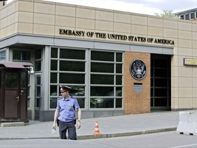 FILE - In this Tuesday, May 14, 2013 file photo, a Russian policeman stands in front of an entrance of the U.S. Embassy in downtown Moscow, Russia. The U.S. Embassy in Russia will suspend issuing nonimmigrant visas in Moscow for eight days from Wednesday and will stop issuing visas at its consulates elsewhere in Russia in response to the Russian decision to cap embassy staff, the embassy said Monday, Aug. 21, 2017. (AP Photo/Ivan Sekretarev, file)