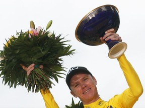 FILE - In this Sunday, July 23, 2017 file photo, Tour de France winner Britain's Chris Froome, wearing the overall leader's yellow jersey, holds the trophy on the podium after the twenty-first and last stage of the Tour de France cycling race over 103 kilometers (64 miles) with start in Montgeron and finish in Paris, France. After winning the Tour de France for a fourth time, Chris Froome now will try to break his run of second-place finishes at the Spanish Vuelta which starts Saturday Aug. 19, 2017. (AP Photo/Christophe Ena, File)