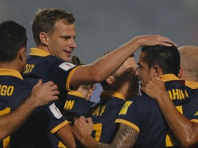 FILE- In this Tuesday, Nov. 17, 2015 file photo, Australia's Tim Cahill, second left, celebrates with teammates after scoring a goal against Bangladesh during their 2018 FIFA World Cup qualifying soccer match in Dhaka, Bangladesh. Three more teams will join Iran in qualifying for the World Cup from Asia over the next week. South Korea and Uzbekistan are vying for the second automatic qualifying spot in Group A after Iran. In Group B, there is a three-way tussle between Japan, Saudi Arabia and Australia to finish in the top two. (AP Photo/ A.M. Ahad, File)