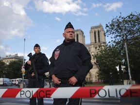 FILE - In this Tuesday, June 6, 2017 file photo, police officers seal off the access to Notre Dame cathedral, seen in the background, after a man attacked officers with a hammer outside the famous landmark, in Paris, France. The soldiers of France's Sentinelle operation, along with other security forces patrolling French streets, are increasingly the main targets of attacks. Knives, machetes, hammers and vehicles have been used in the seven attacks this year - in each case against security forces - despite France's state of emergency. In the latest, on Wednesday, Aug. 9 a BMW slammed into six soldiers as they left their barracks outside Paris for duty in what authorities said was a "deliberate" attack. (AP Photo/Christophe Ena, file)