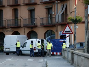 Police block the entrance of a telephone call centre as they search the premises in Ripoll, Spain, Tuesday Aug. 22, 2017. The lone fugitive from the Spanish cell that killed several people in and near Barcelona was shot to death Monday after he flashed what turned out to be a fake suicide belt at two troopers who confronted him in a vineyard just outside the city he terrorized, authorities said. (AP Photo/Francisco Seco)