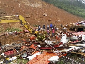 In this image made available by Society 4 Climate Change Communication - Sierra Leone, people survey the damage after mudslides in Regent, east of Freetown, Sierra Leone, Monday Aug. 14, 2017. Mudslides after heavy rains and flooding killed scores of people in Sierra Leone's capital on Monday. (Society 4 Climate Change Communication via AP)