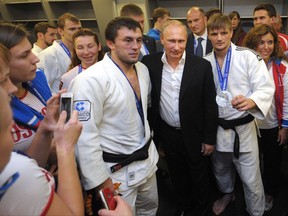 FILE - This is a Sunday, Aug. 31, 2014  file photo of Russian President Vladimir Putin, center right, as he poses for a photo with athletes while attending the Judo World Cup in the city of Chelyabinsk in Siberia, Russia. Russian President Vladimir Putin is expected to be  visiting Hungary on Monday Aug. 28, 2017 for the second time this year to attend the World Judo Championships being held in Budapest.  (Alexei Druzhinin, RIA Novosti, Presidential Press Service/File via AP)