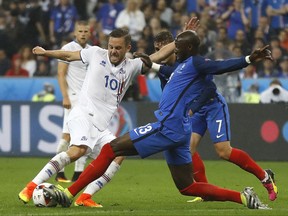 FILE - In this Sunday, July 3, 2016 file photo, Iceland's Gylfi Sigurdsson, left, and France's Eliaquim Mangala challenge for the ball during the Euro 2016 quarterfinal soccer match between France and Iceland, at the Stade de France in Saint-Denis, north of Paris, France. Everton says it has signed Iceland midfielder Gylfi Sigurdsson from Swansea for a club-record fee, further strengthening the team's attacking options to compensate for the departure of striker Romelu Lukaku. (AP Photo/Frank Augstein, File)