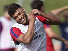 England soccer player Alex Oxlade-Chamberlain smiles during an England training session at St George's Park, Burton, England, Thursday Aug. 31, 2017.  Alex Oxlade-Chamberlain on Thursday left Arsenal after six years to join Premier League rival Liverpool for an initial fee of 35 million pounds ($45 million). The 24-year-old Oxlade-Chamberlain allowed his Arsenal contract to enter its final season after rejecting offers of a new deal. He had been linked with a move across London to Chelsea.(Aaron Chown/PA via AP)