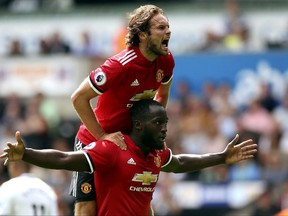 Manchester United's Romelu Lukaku, centre, celebrates scoring his side's second goal with team-mate Daley Blind during the English Premier League soccer match between Swansea and Manchester United, at the Liberty Stadium, in Swansea, Wales, Saturday Aug. 19, 2017. (Nick Potts/ PA via AP)