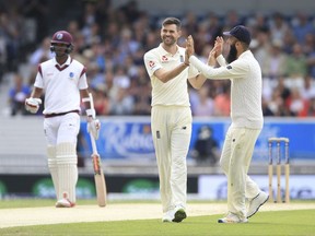 England's James Anderson, centre, celebrates with Moeen Ali after taking the wicket of West Indies Devendra Bishoo during day two of the the second cricket Test Match at Headingley, Leeds. England, Saturday Aug. 26, 2017. (Nigel French/PA via AP)