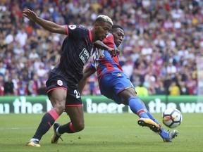 Huddersfield Town's Steve Mounie, left, and Crystal Palace's Timothy Fosu-Mensah battle for the ball during the English Premier League soccer match at Selhurst Park, London, Saturday, August 12, 2017. (Scott Heavey/PA via AP)