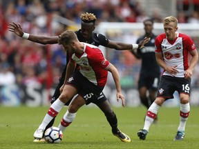 Swansea City's Tammy Abraham, left, and Southampton's Jack Stephens battle for the ball during the English Premier League soccer match at St Mary's Stadium, Southampton, England, Saturday, Aug. 12, 2017. (Paul Harding/PA via AP)