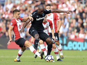 Southampton's Dusan Tadic, left and West Ham United's Angelo Ogbonna battle for the ball, during the English Premier League soccer match between Southampton and West Ham,  at St Mary's, in Southampton, England, Saturday, Aug. 19, 2017. (Adam Davy/ PA via AP)