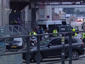 In this image taken from video people and security stand around a van in Rotterdam, Wednesday Aug. 23, 2017, after a concert by an American rock band was cancelled Wednesday night following a threat, the city's mayor said. Police detained the driver of a van with Spanish license plates carrying a number of gas tanks inside. (RTL via AP)