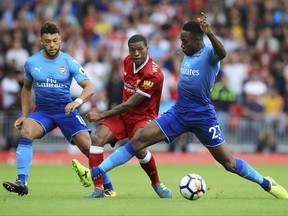 Arsenal's Alex Oxlade-Chamberlain, left, and Arsenal's Danny Welbeck, right, battle for the ball with Liverpool's Georginio Wijnaldum during the English Premier League soccer match at Anfield, Liverpool, England, Sunday, Aug. 27, 2017. (Peter Byrne/PA via AP)