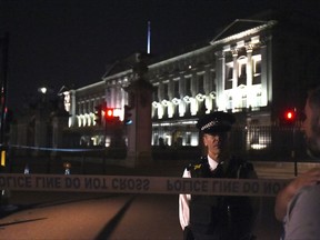 A police cordon outside Buckingham Palace where a man has been arrested after an incident, in London, Friday Aug.  25, 2017. A man armed with a knife was detained outside London's Buckingham Palace Friday evening, and two police officers were injured while arresting him, police said. (Lauren Hurley/PA via AP)