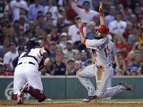 St. Louis Cardinals' Matt Carpenter, right, tries to avoid a tag by Boston Red Sox catcher Christian Vazquez during the second inning of a baseball game in Boston, Wednesday, Aug. 16, 2017. Carpenter was out. (AP Photo/Charles Krupa)