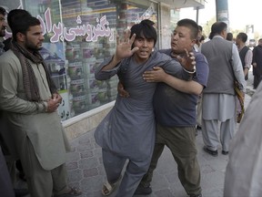 A shocked man shouts slogans against President Ghani after he ran out of the Shiite mosque during an ongoing attack, Kabul, Afghanistan, Friday, Aug. 25, 2017. Gunmen stormed a Shiite mosque in the Afghan capital while worshippers were at Friday prayers, setting off an explosion that killed a security guard outside and pushing into the shrine, officials said. (AP Photo/Massoud Hossaini)