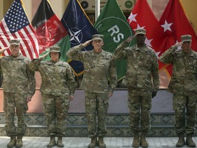 FILE - In this Saturday, July 15, 2017 file photo, Army Gen. John W. Nicholson, center, commander of the Resolute Support mission and U.S. forces in Afghanistan; outgoing Maj. Gen. Richard G. Kaiser, left, and incoming Maj. Gen. Robin L. Fontes, second left, salute during a change of command ceremony at Resolute Support headquarters, in Kabul, Afghanistan. In an "open letter" to U.S. President Donald Trump, Afghanistan's Taliban on Tuesday reiterated their call for a withdrawal of troops to end the protracted war. (AP Photos/Massoud Hossaini)