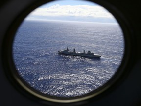 In this March 31, 2014 file photo, HMAS Success scans the southern Indian Ocean, near the coast of Western Australia, as a Royal New Zealand Air Force P3 Orion flies over, while searching for missing Malaysia Airlines Flight MH370. Scientists have potentially narrowed the search area for the missing Malaysian airliner to three specific locations in the southern Indian Ocean, through new satellite and drift analysis of the 2014 crash released Wednesday, Aug. 16, 2017.