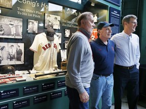 Billy, left, and Richie Conigliaro, center, pose with Boston Red Sox President and CEO Sam Kennedy in front of a newly unveiled display case at Fenway Park featuring memorabilia from the career of their brother, former Red Sox player Tony Conigliaro, before the team's baseball game against the New York Yankees, Friday, Aug. 18, 2017, in Boston. (AP Photo/Michael Dwyer)