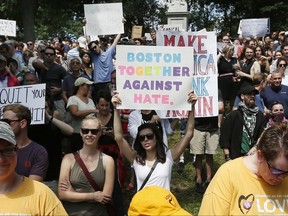 Counterprotesters hold signs at a "Free Speech" rally by conservative activists on Boston Common, Saturday, Aug. 19, 2017, in Boston. Thousands of demonstrators marched Saturday from the city's Roxbury neighborhood to Boston Common, where the "Free Speech Rally" is being held. (AP Photo/Michael Dwyer)