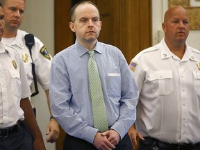 In this July 21, 2015 photo, officers lead Radoslaw Czerkawski into court for sentencing in Dedham, Mass., after he was convicted of larceny. Czerkawski, who is charged with abusing a dog so severely it had to be euthanized, faces multiple animal cruelty charges in the trial scheduled to start Tuesday, Aug. 8, 2017, in Massachusetts. (Greg Derr/The Quincy Patriot Ledger via AP)