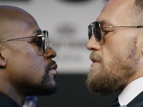 Floyd Mayweather Jr., left, and Conor McGregor pose for photographers during a news conference Wednesday, Aug. 23, 2017, in Las Vegas.