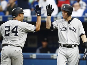 Gary Sanchez, left, is congratulated by New York Yankees teammate Todd Frazier after hitting a solo home run against the Blue Jays during the second inning in Toronto on Wednesday night.