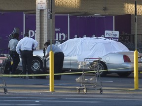 Baltimore County police investigate a fatal shooting outside a store Tuesday, Aug. 1, 2017, in Catonsville, Md. Authorities said a police officer working security at the store fatally shot a man suspected of shoplifting during a confrontation. (Jeffrey F. Bill/The Baltimore Sun via AP)