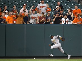 Oakland Athletics left fielder Rajai Davis chases after a fly ball single that was hit by Baltimore Orioles' Chris Davis in the second inning of a baseball game in Baltimore, Monday, Aug. 21, 2017. (AP Photo/Patrick Semansky)