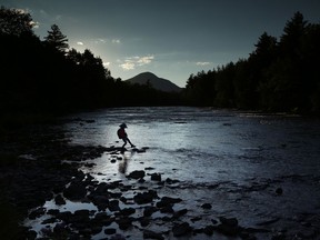 In this Tuesday, Aug. 8, 2017 photo, a youngster explores the Penobscot River's East Branch at the new Katahdin Woods and Waters National Monument near Patten, Maine. Interior Secretary Ryan Zinke wants to retain the newly created Katahdin Woods and Waters National Monument in northern Maine, but said he might recommend adjustments to the White House on Thursday, Aug. 24, 2017. (AP Photo/Robert F. Bukaty)