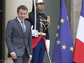 FILE - In this Monday, July 31, 2017 file photo file French President Emmanuel Macron walk out of the Elysee Palace in Paris, France. France's lower house of parliament is voting on a draft law allowing President Emmanuel Macron to push through a series of controversial labor reforms that are central to his strategy for reinvigorating the economy. (AP Photo/Michel Euler)