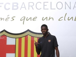 French soccer player Ousmane Dembele gestures during his arrival at the club's office at the Camp Nou stadium in Barcelona, Spain, Sunday, Aug. 27, 2017. Barcelona is shoring up its attack following Neymar's departure by buying Ousmane Dembele from Borussia Dortmund in a deal that could reach 147 million euros (about $173 million), second only to the Brazilian star's world-record transfer. (AP Photo/Manu Fernandez)