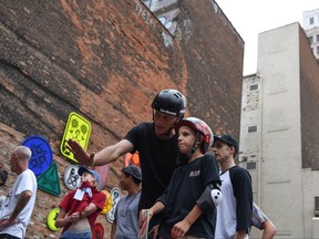 Skateboarding legend Tony Hawk helps a young skateboarder on the mini ramp at the opening of the new Wayfinding skate park in downtown Detroit, Tuesday, Aug. 15, 2017. Hawk helped design the temporary public park, at Monroe Ave. and Randolph St. near Cadillac Square, alongside Bedrock Detroit, Quicken Loans, Library Street Collective and the Cranbrook Art Museum. (Tanya Moutzalias/The Ann Arbor News-MLive.com Detroit via AP)