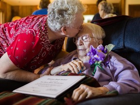Iris Weatherwax, 97, receives a kiss from her daughter, Beverly Weatherwax, 70, of Flint, after belatedly being awarded her high school diploma in a private ceremony on Wednesday, Aug. 23, 2017, at her residence in Grand Blanc. Weatherwax was barred from graduating from the Davison Community School District in 1938 because she was pregnant at the time, despite the fact that she was also married. Before Wednesday's ceremony, Weatherwax asked, "Is it alright if I cry?" (Terray Sylvester/The Flint Journal-MLive.com via AP)
