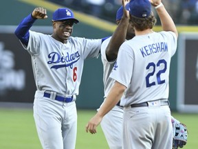 Los Angeles Dodgers outfielders Curtis Granderson, left, and Yasiel Puig, center, high five pitcher Clayton Kershaw following the Dodgers' 3-0 win over the Detroit Tigers in a baseball game, Saturday, Aug. 19, 2017, in Detroit. (AP Photo/Lon Horwedel)