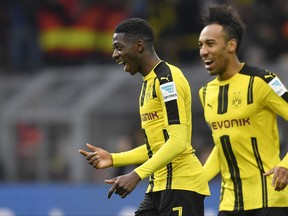 FILE - In this Feb. 18, 2017 file photo Borussia Dortmund's Ousmane Dembele of France, left, celebrates beside teammate Pierre-Emerick Aubameyang during the Bundesliga soccer match against VfL Wolfsburg in Dortmund, Germany. Borussia Dortmund's CEO Hans-Joachim Watzke said at the annual balance press conference Friday, Aug. 25, 2017 that he is optimistic about the record transfer of the 20-year-old Ousmane Dembele to FC Barcelona very soon. (AP Photo/Martin Meissner, file)