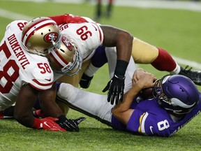 Minnesota Vikings quarterback Sam Bradford (8) is tackled by San Francisco 49ers defenders Elvis Dumervil (58) and DeForest Buckner (99) during the first half of an NFL preseason football game Sunday, Aug. 27, 2017, in Minneapolis. (AP Photo/Jim Mone)