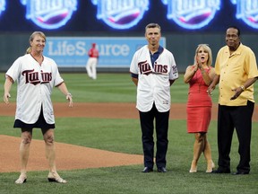 Former Minnesota Twin Rod Carew, right, and his wife, Rhonda, watch along with Ralph Reuland after his wife, Mary, left, threw out a ceremonial first pitch, part of donor day, before the Twins' baseball game against the Arizona Diamondbacks on Friday, Aug. 18, 2017, in Minneapolis. Carew received a new heart and kidney from the Reulands' late son Konrad, a former NFL player. (AP Photo/Jim Mone)