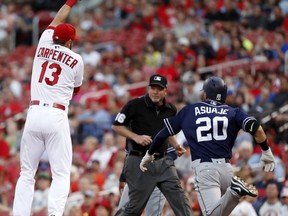 San Diego Padres' Carlos Asuaje (20) is safe at first for a single as the throw goes over the head of St. Louis Cardinals first baseman Matt Carpenter (13) during the first inning of a baseball game Tuesday, Aug. 22, 2017, in St. Louis. (AP Photo/Jeff Roberson)