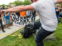 A protester kicks the toppled statue of a Confederate soldier after it was pulled down in Durham, N.C. Monday, Aug. 14, 2017.