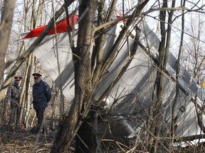 FILE - In this file photo dated Saturday, April 10, 2010, Russian police officers walk near to wreckage at the plane crash site near Smolensk, western Russia.  Poland expressed concerns to Russia on Tuesday Aug. 29, 2017, over what it called "difficulties" in accessing the site of the 2010 plane crash in Russia that killed Poland's President Lech Kaczynski and 95 others.  (AP Photo/Sergey Ponomarev, FILE)
