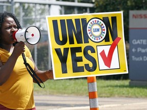 A UAW supporter uses a bull horn to remind eligible workers to vote for the union while standing outside an employee vehicle entrance at the Nissan vehicle assembly plant in Canton, Miss., Friday, Aug. 4, 2017. Union members set up informational lines outside employee entrances at the plant and greeted all shifts of workers arriving and leaving, reminding workers to vote for the union. The vote for union representation of line workers concludes Friday evening. (AP Photo/Rogelio V. Solis)