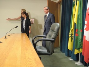 CORRECTS SPELLING OF WALL'S WIFE TO TAMI Premier of Saskatchewan Brad Wall, his wife Tami, and chief of operations and communications Kathy Young, back, enter a press conference where Wall announced he is retiring from politics at the Legislative Building in Regina, Sask., on Thursday, August 10, 2017. THE CANADIAN PRESS/Mark Taylor