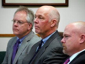 FILE - In this June 12, 2017 file photo, Congressman-elect Greg Gianforte, center, sits alongside William Mercer, left, and Todd Whipple during his court hearing in Bozeman, Mont. Gianforte has been photographed and fingerprinted after pleading guilty to assaulting a reporter on the eve of the special election that put him in office. Gallatin County jail records indicate the booking process Friday, Aug. 25, 2017 took 23 minutes, beginning at 6:37 a.m. (Freddy Monares/Bozeman Daily Chronicle via AP, File)
