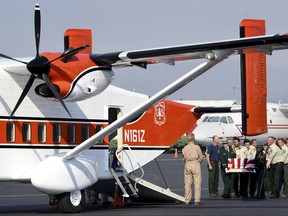 Pallbearers from the U.S. Forest Service load the body of Brent Witham into a Forest Service Sherpa in Missoula, Mont., Monday, Aug. 7, 2017, for transport to California for memorial services. Witham, a firefighter with the Vista Grande Hotshot crew in California, died Aug. 2 when he was struck by a falling tree while assigned to the Lolo Peak fire . (Kurt Wilson /The Missoulian via AP)