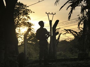 In this Friday, July 14, 2017, photo, a border patrol stands guard at a police post that was previously attacked by a Muslim terrorist group in Kyee Kan Pyin, Buthidaung, Rakhine state Myanmar. Muslim militants armed with guns and machetes attacked Myanmar police and border outposts in a troubled northern state, with 12 deaths confirmed so far, police said Friday. (AP Photo/ Esther Htusan)