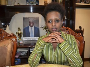 FILE - In this Sunday, May 14, 2017 file photo, women's rights activist and presidential candidate Diane Shima Rwigara, 35, is photographed next to a portrait of her father, business tycoon Assinapol Rwigara, at her home in Kigali, Rwanda. The brother of the former presidential hopeful in Rwanda said Thursday, Aug. 31, 2017, that Diane Rwigara and four other family members are in police custody. (AP Photo, File)
